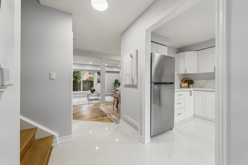 Main-floor hallway with marble-look tile leading to the living area and kitchen