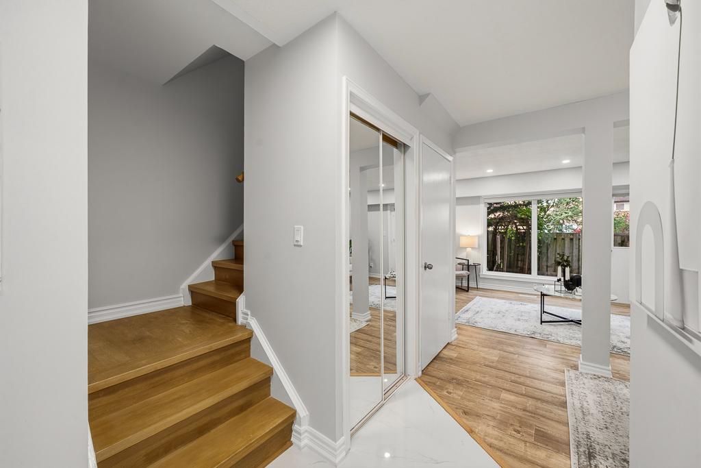 Hardwood staircase with new flooring and view across the main floor